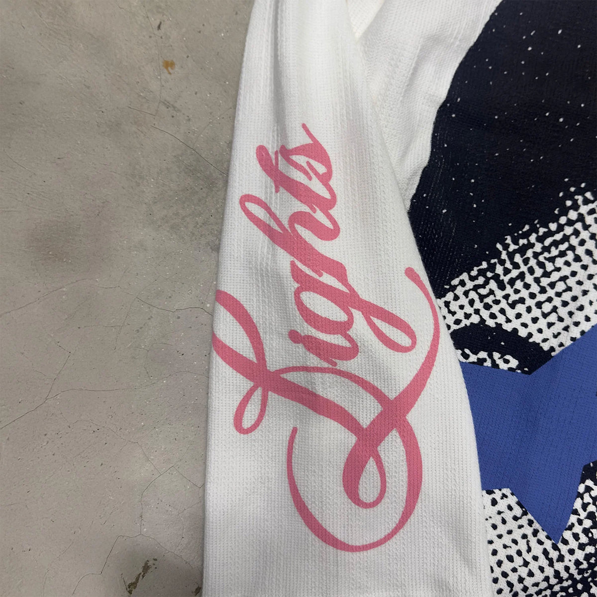 White long-sleeve T-shirt with pink logo script on sleeve