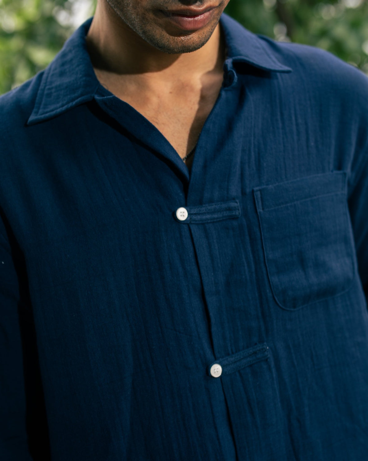 Navy button-up shirt close-up showing collar, placket, and chest pocket
