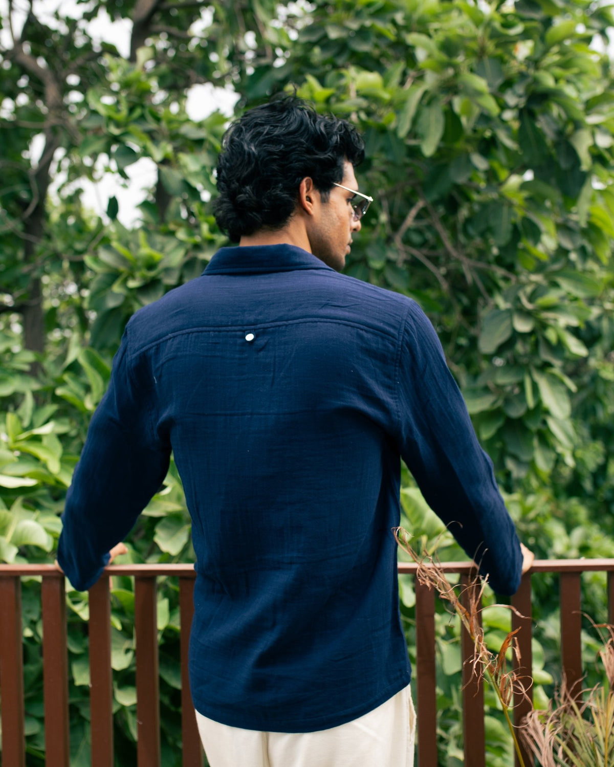 Navy long-sleeve button-up shirt, back view, with button details