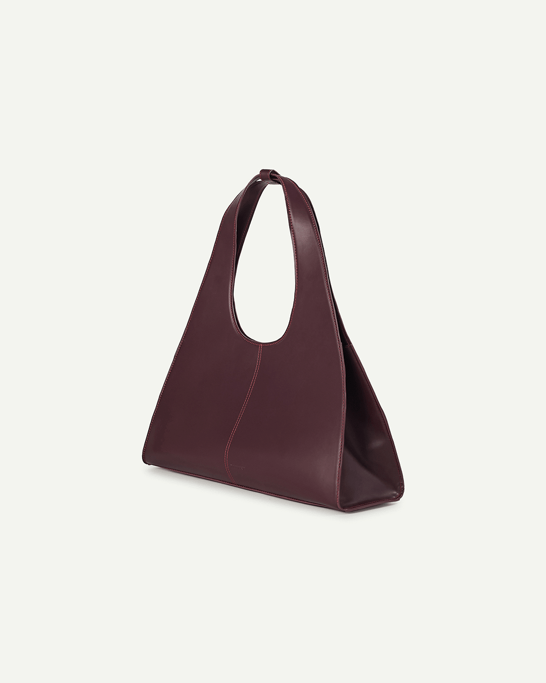 Burgundy leather open-top tote bag, angled view, with top handle and red contrast stitching