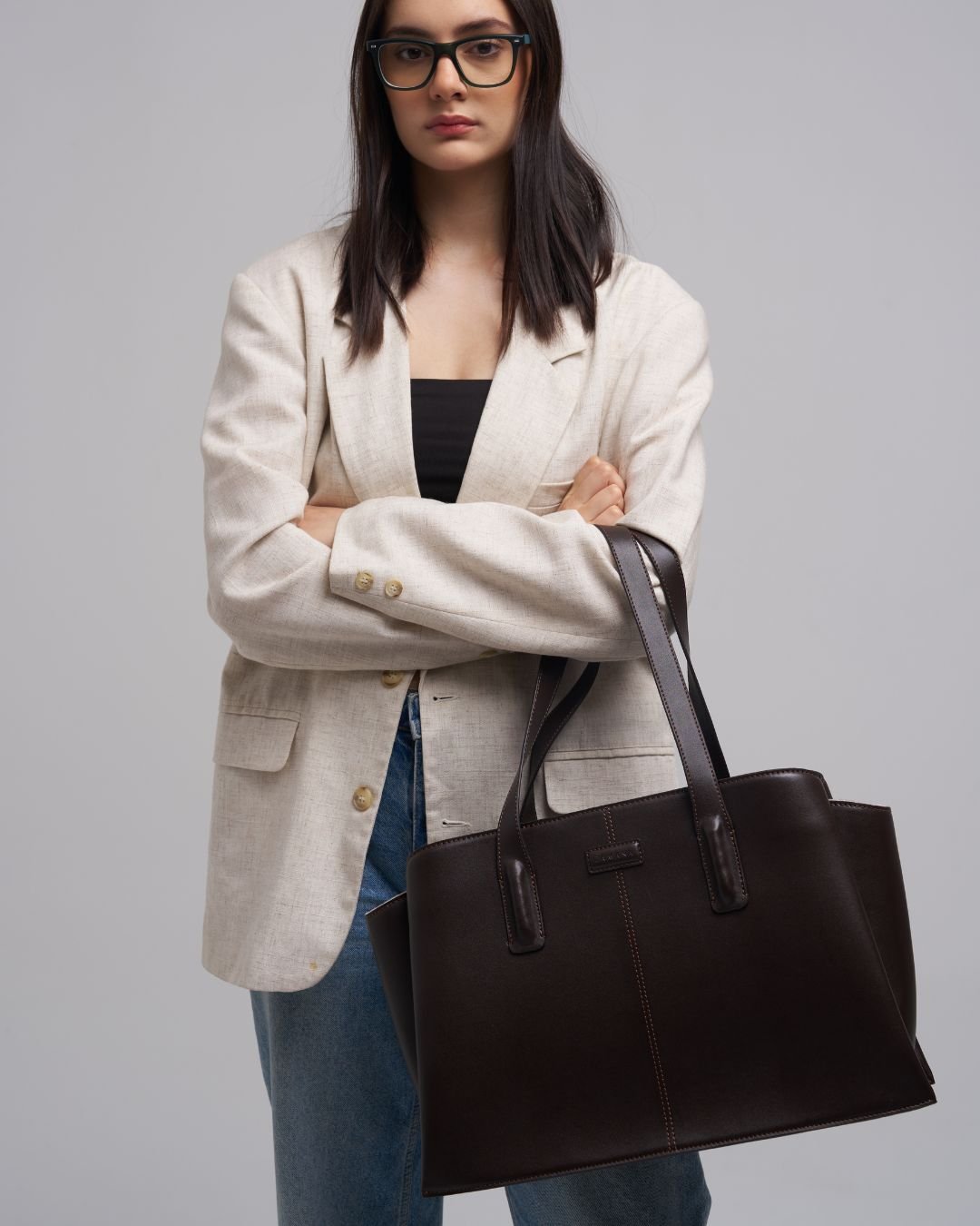 Dark brown leather tote bag with top handles and long shoulder strap