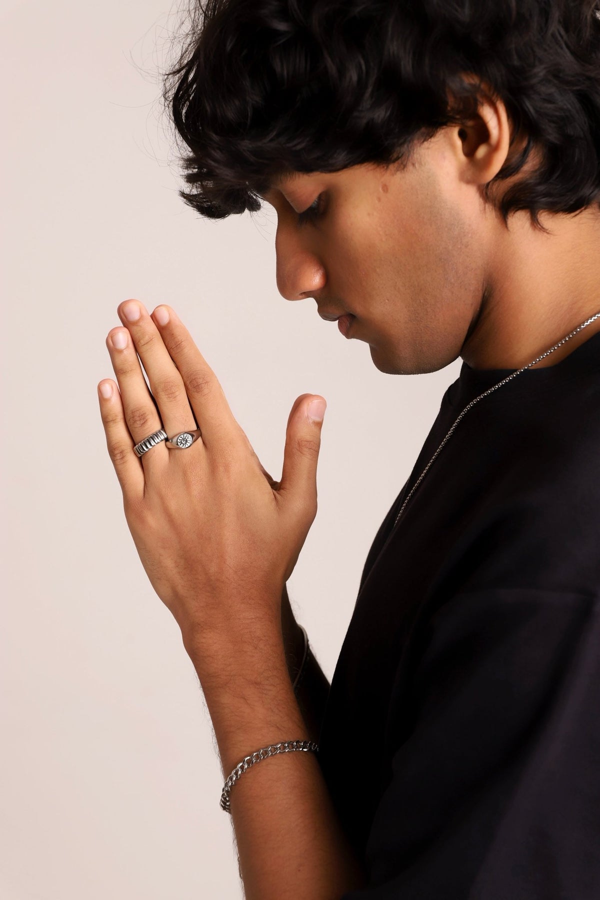 Signet ring on finger with sunburst engraving and round center detail