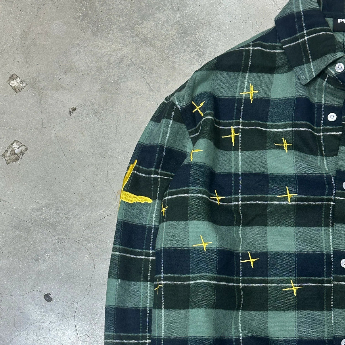 Star-spotted checkered shirt shoulder and sleeve detail, dark green and navy plaid