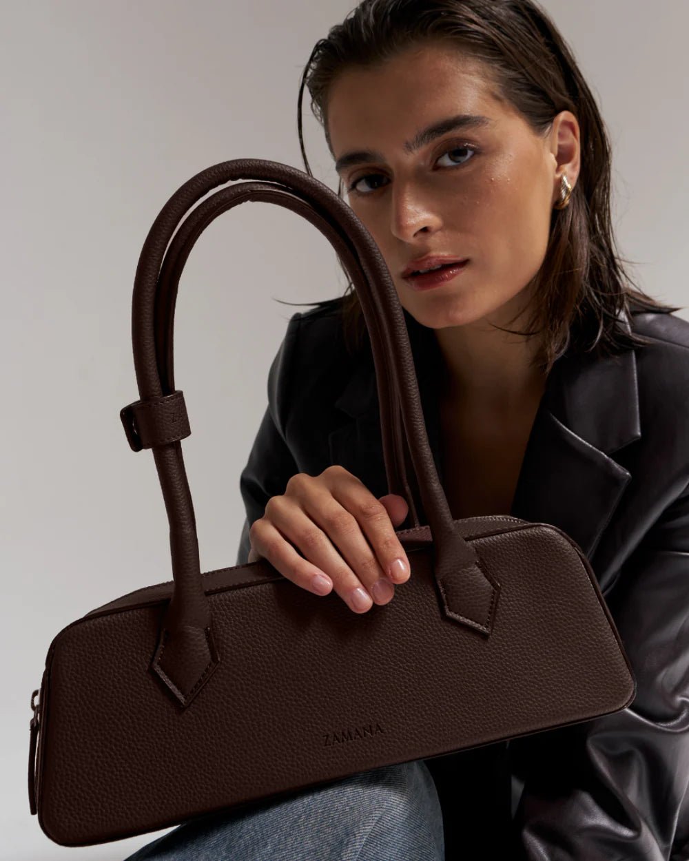 Dark brown structured handbag with two top handles and front seams