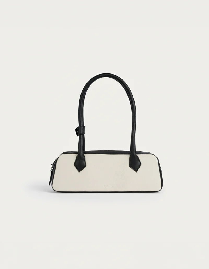 White and black baguette handbag with black top handles and front flap detail