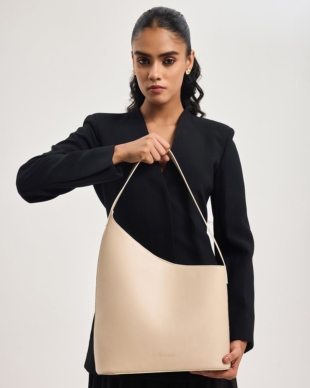 Beige hobo tote bag with wide opening and long handle, model holding bag
