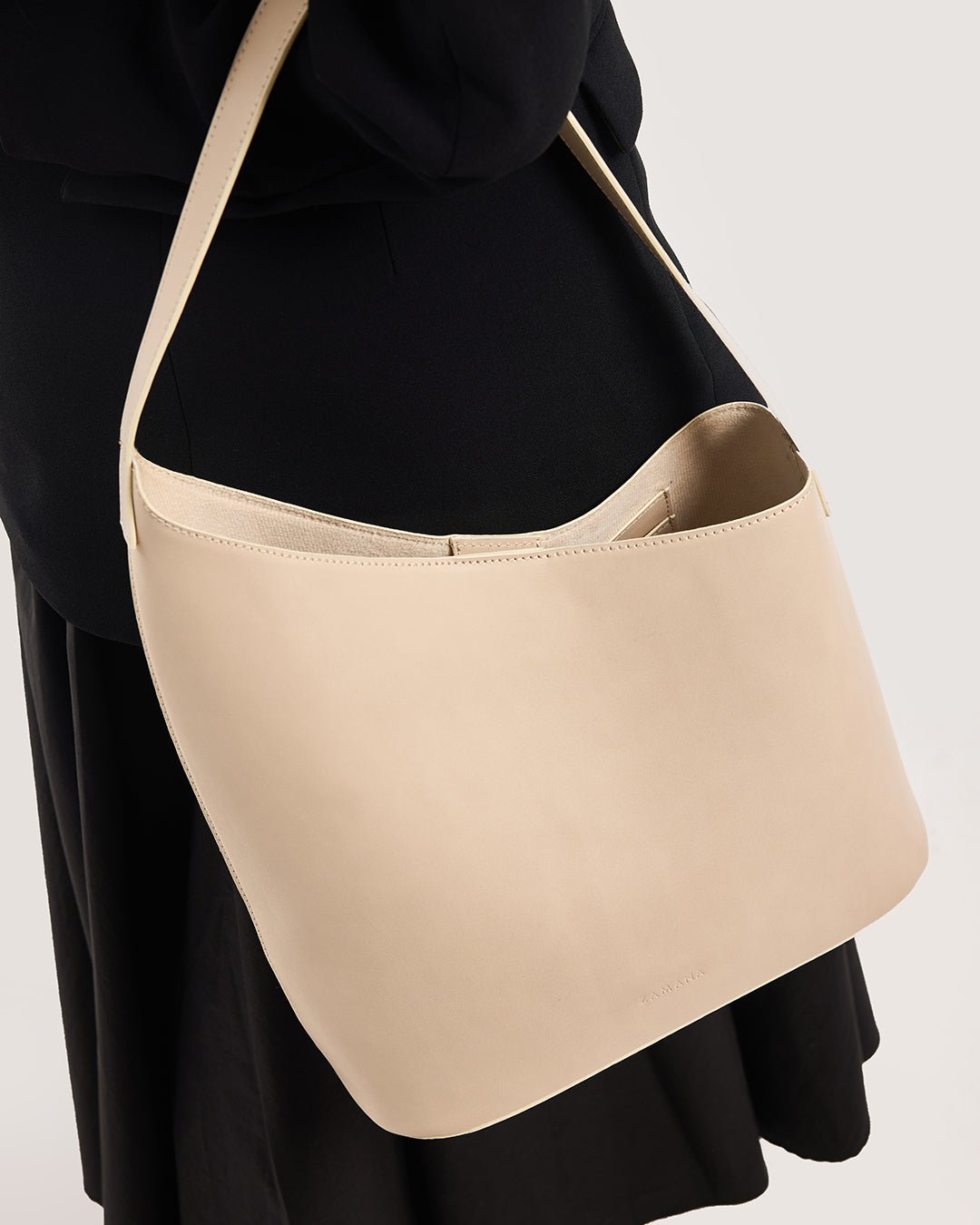 Beige hobo tote bag close-up with curved opening and stitched edges
