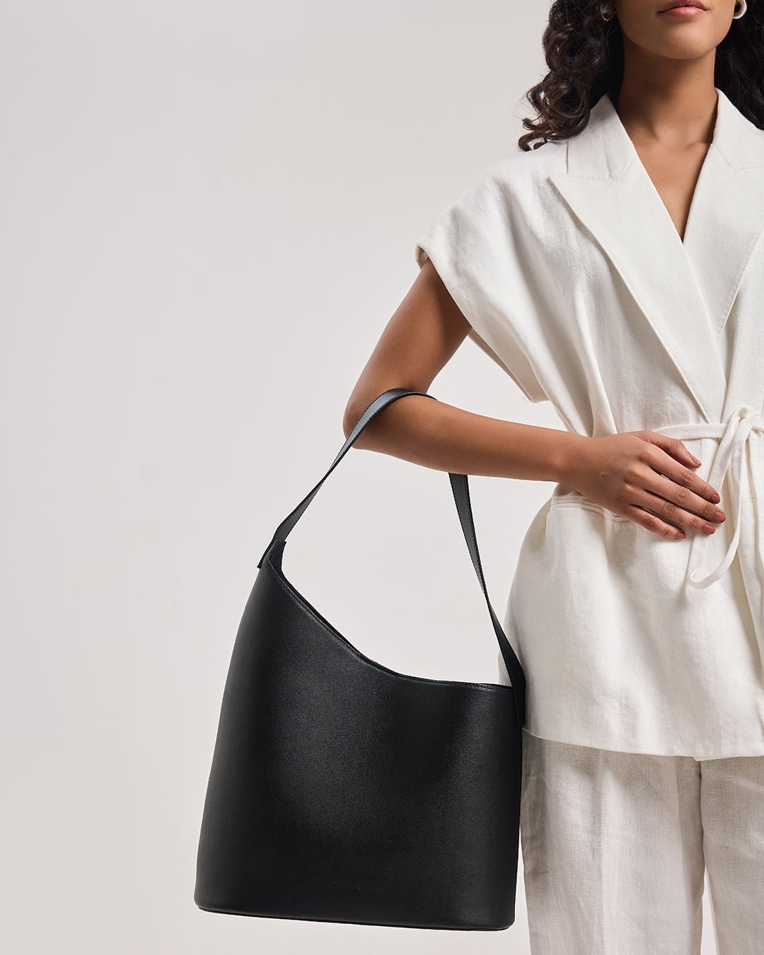 Black leather-style bucket tote with wide strap and open top
