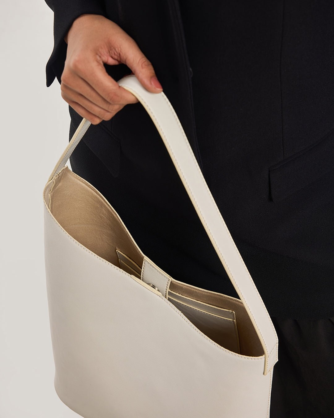 White hobo shoulder bag interior view with tan lining and tan trim edges.