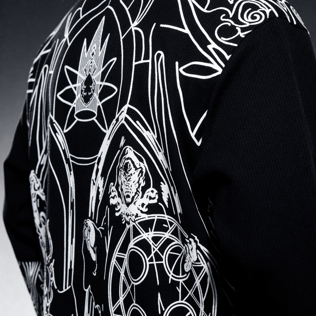 Black waffle-knit long-sleeve shirt with large white character graphic, side close-up