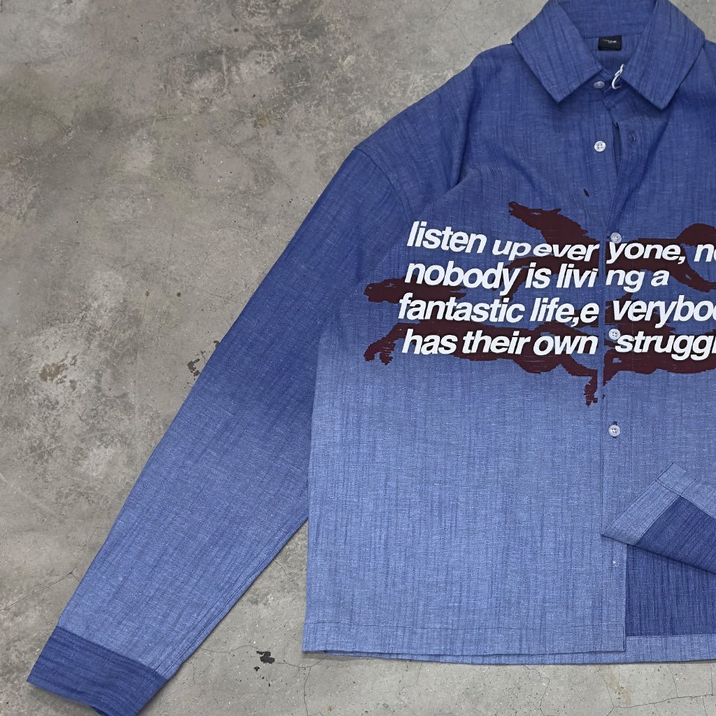 Blue long-sleeve button-down shirt with chest graphic and button placket