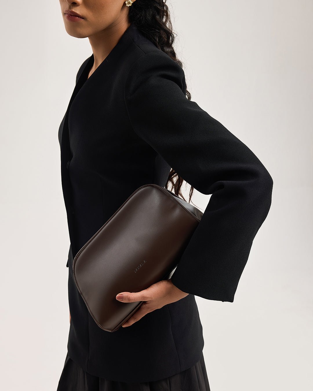 Dark brown leather shoulder clutch bag with strap and rounded top, side view
