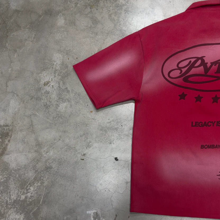 Red shirt back panel with large oval logo and small text beneath, short sleeves