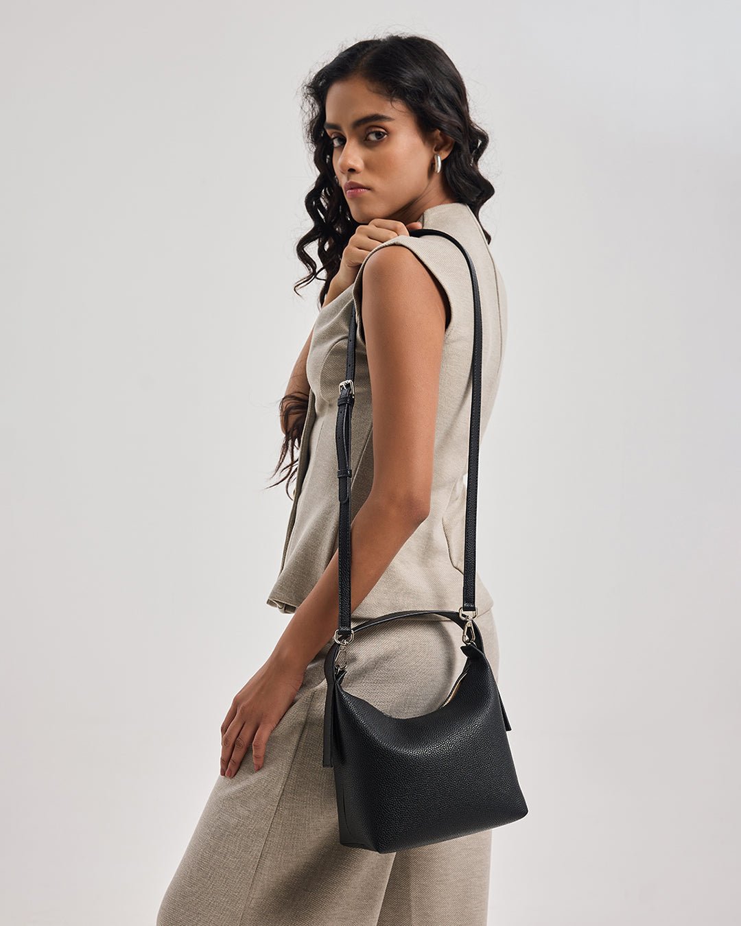 Black hobo bag worn crossbody, front-facing model view