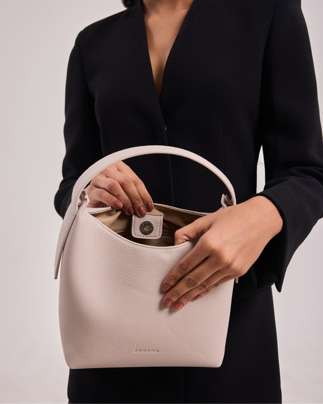 Cream leather-look hobo bag with zip-top opening and visible inner logo patch
