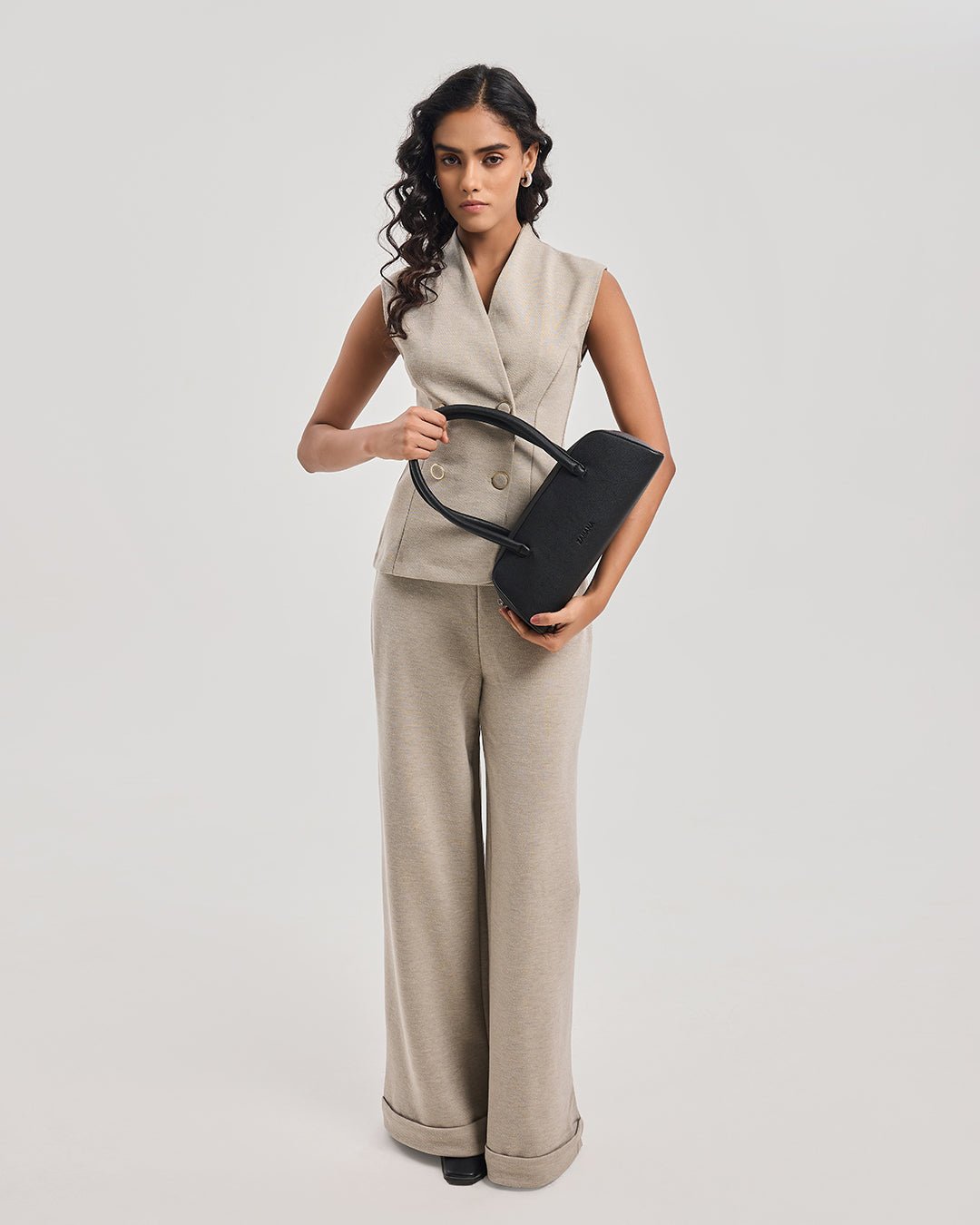 Black top-handle handbag held in front with front zipper and short handles