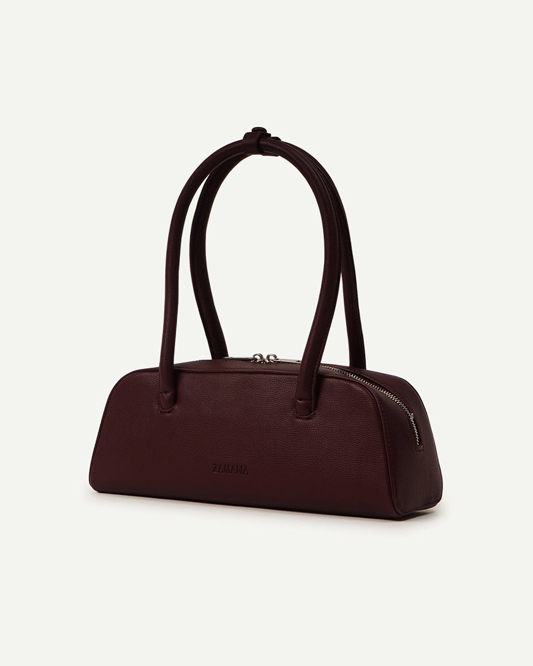 Burgundy mini satchel handbag on side angle with two top handles.