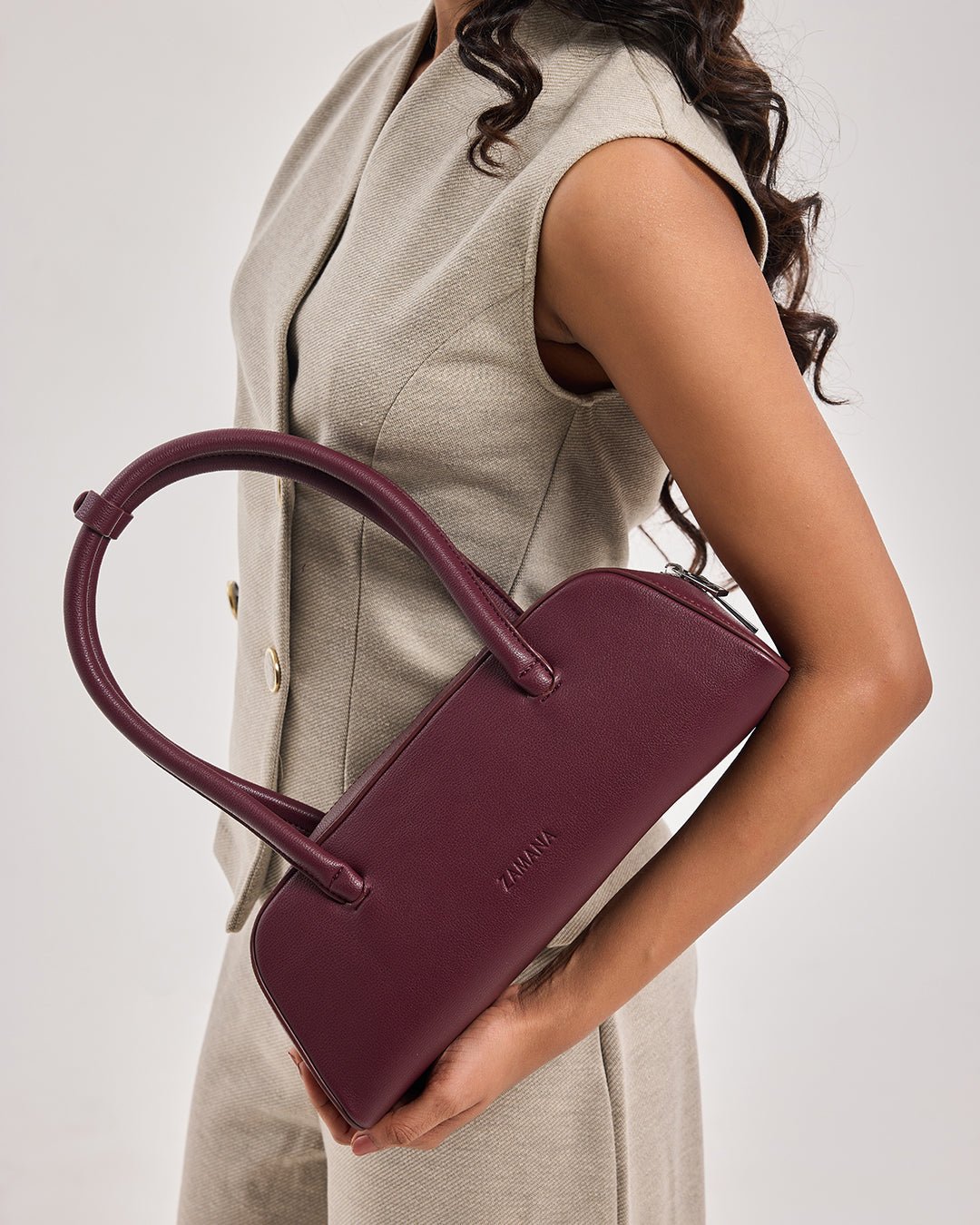 Burgundy mini satchel handbag with top handles and small front logo detail.