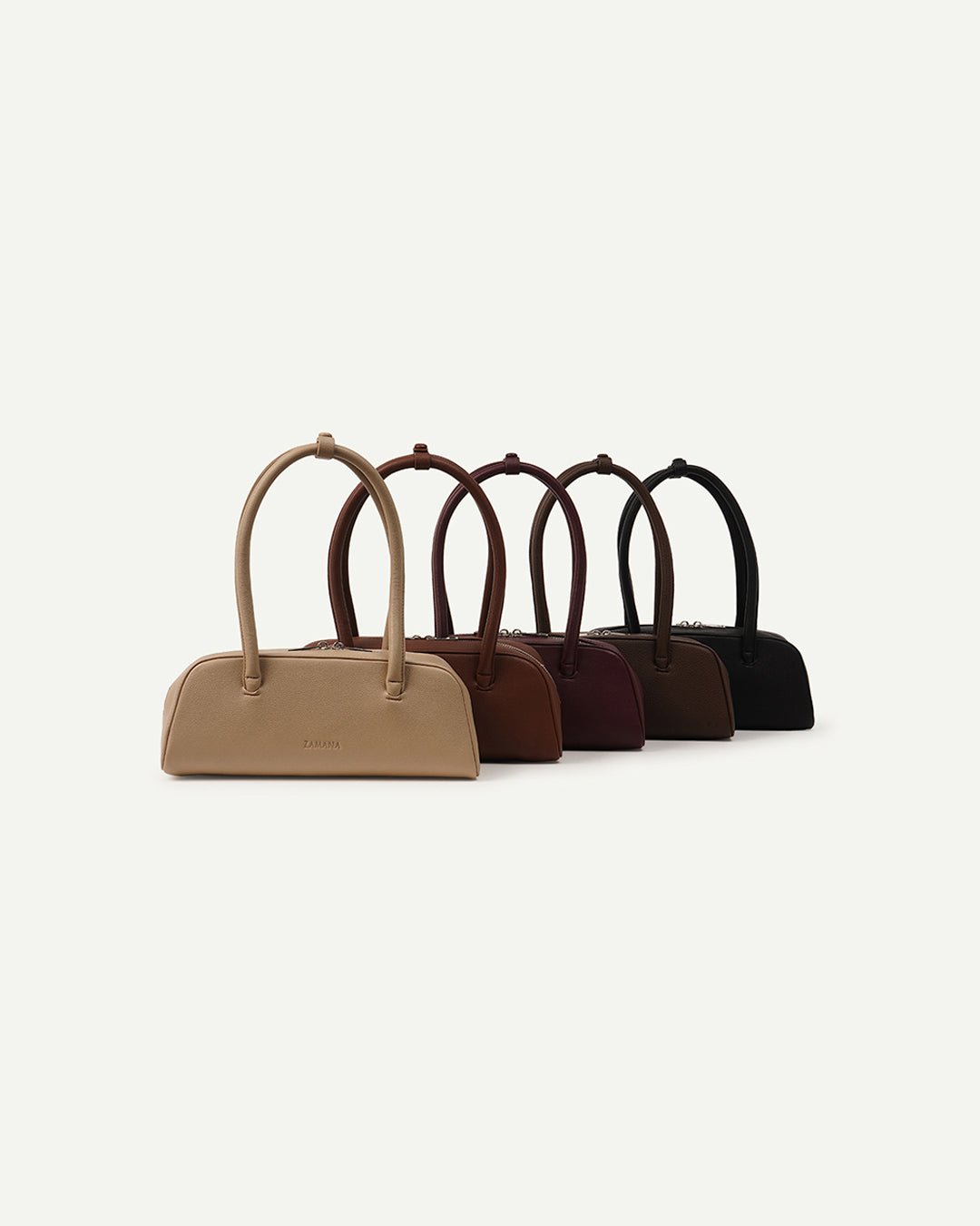 Assorted small top-handle handbags lineup with short handles and zip closures