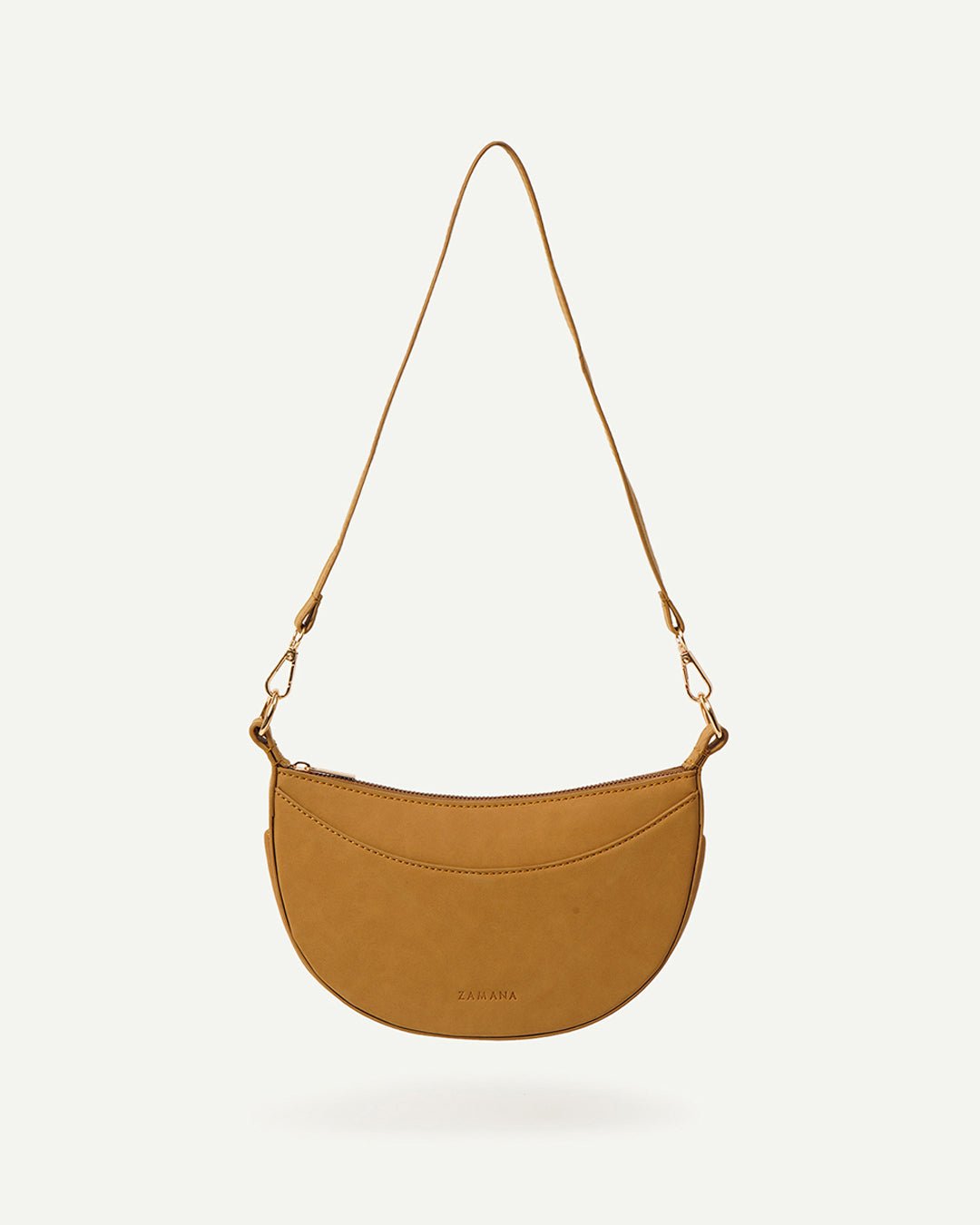 Caramel crescent crossbody bag isolated with adjustable strap and gold-tone clips