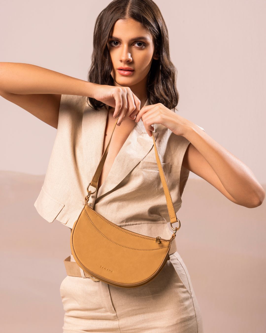 Caramel crescent crossbody bag with adjustable strap and gold-tone hardware