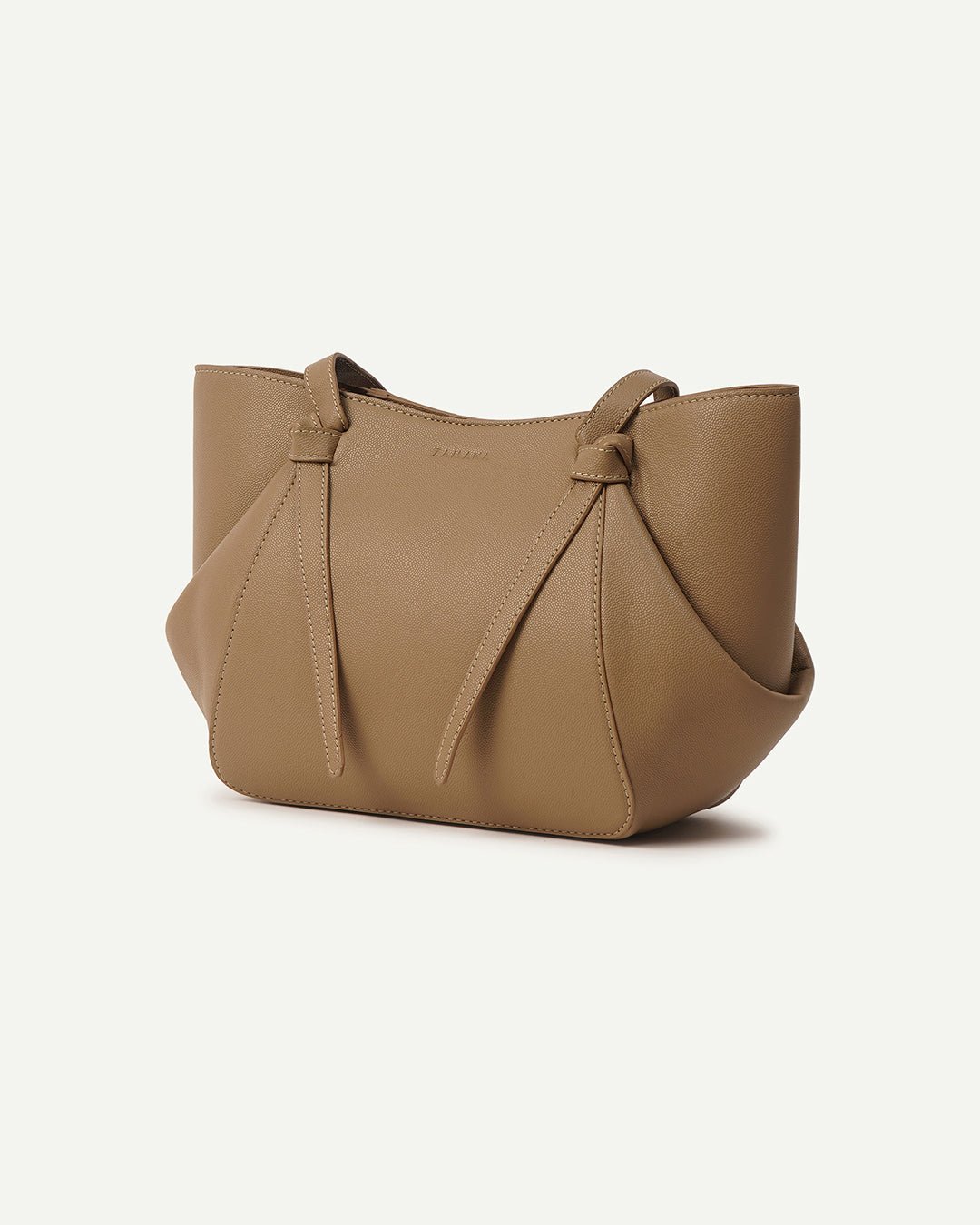 Beige tote bag side view with tassel drawstrings and curved shape