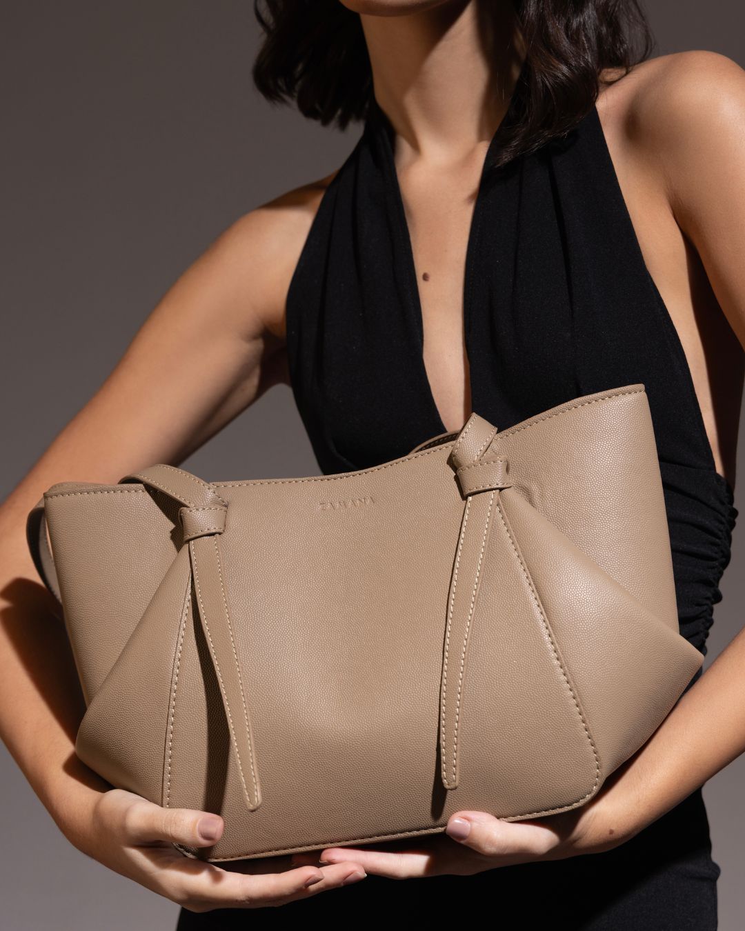 Beige tote bag with tassel drawstrings and top handles