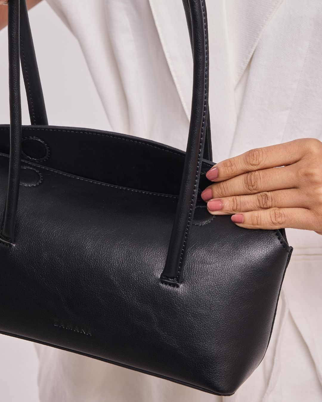 Black leather handbag with top handles and visible stitched detail