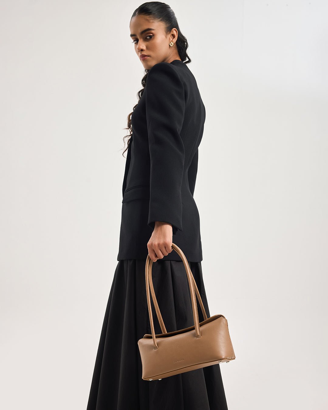 Caramel mini tote bag with two top handles and front logo, worn on arm