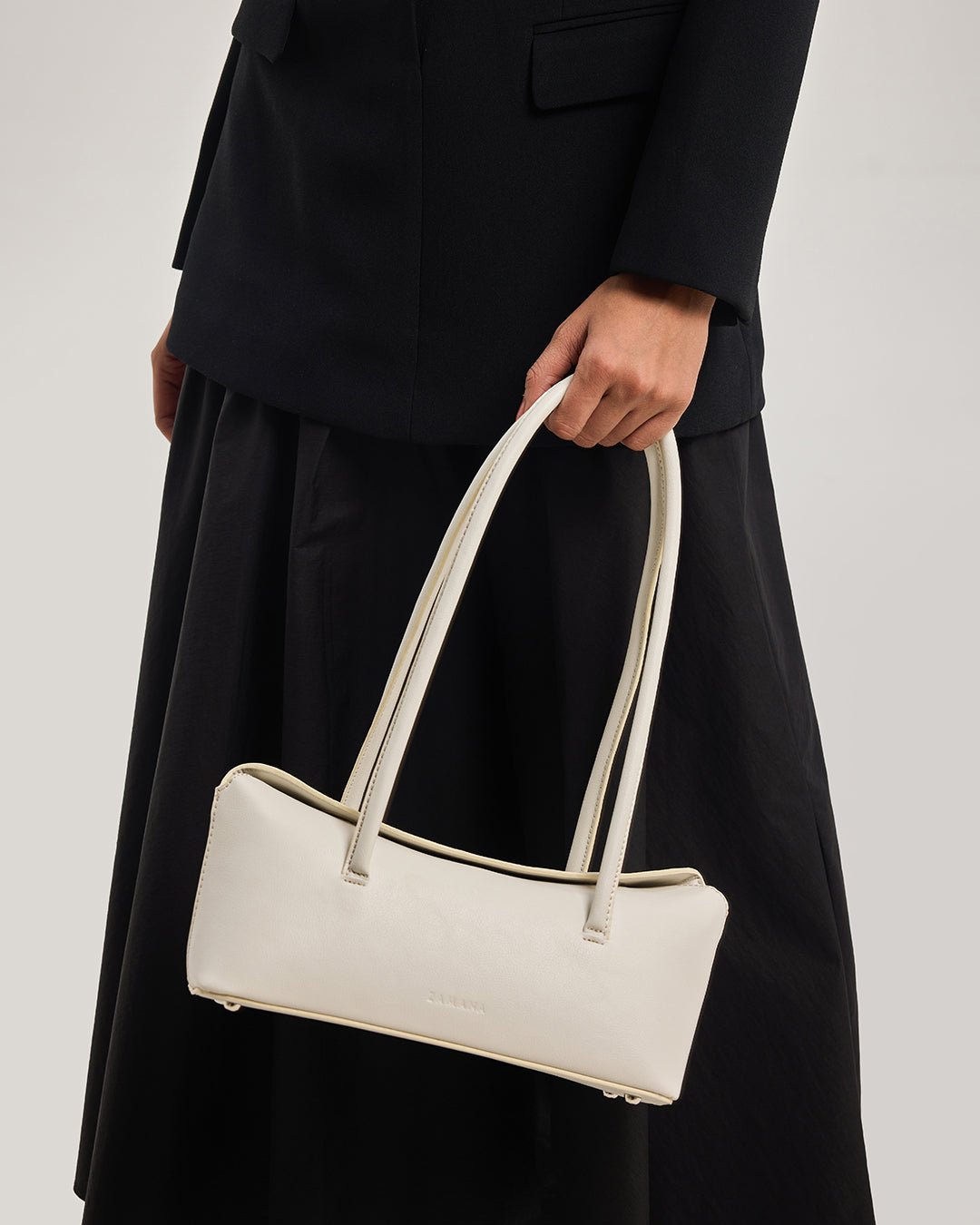Cream tote bag held at the side with double top handles
