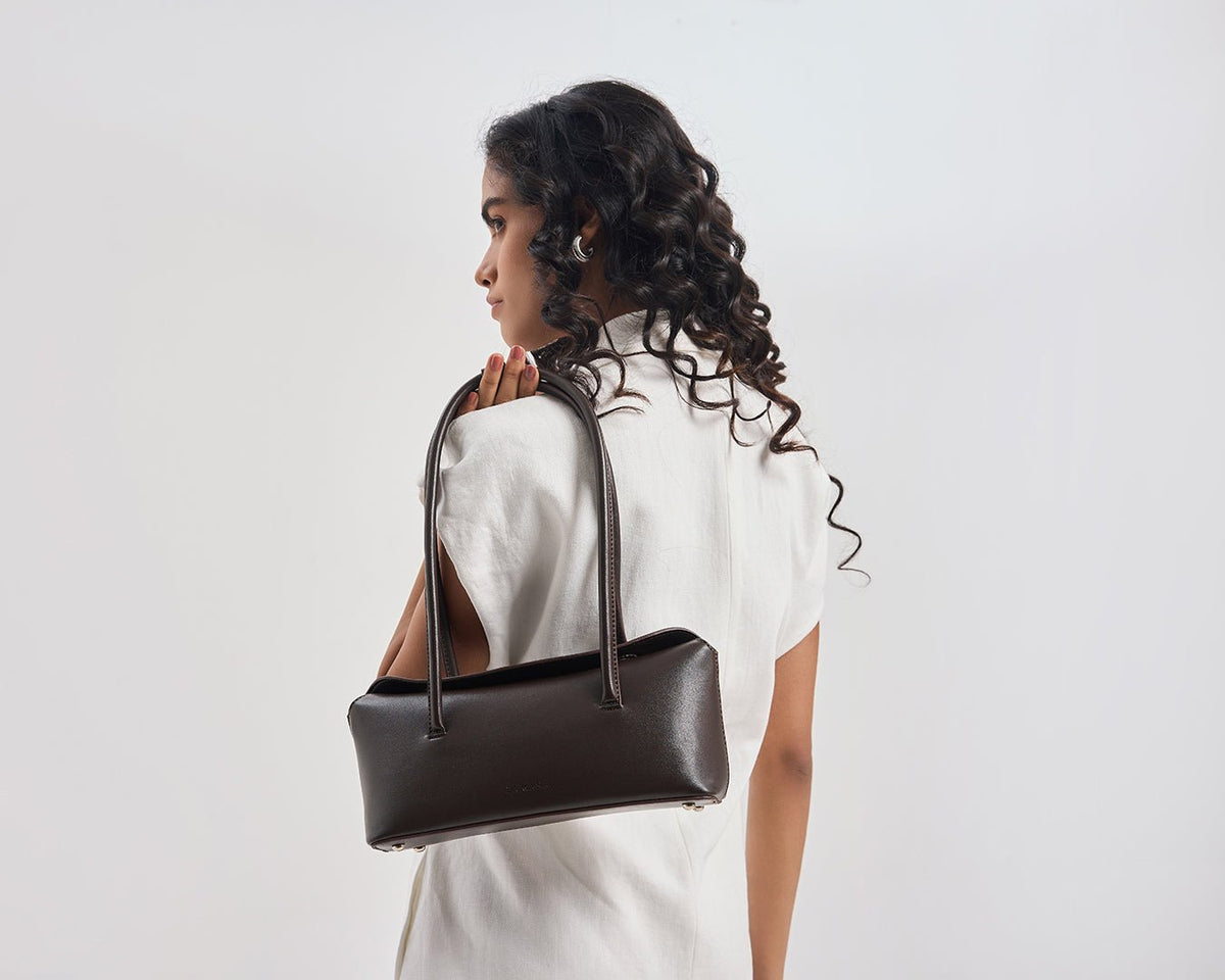 Dark brown tote bag on model, side view with two top handles