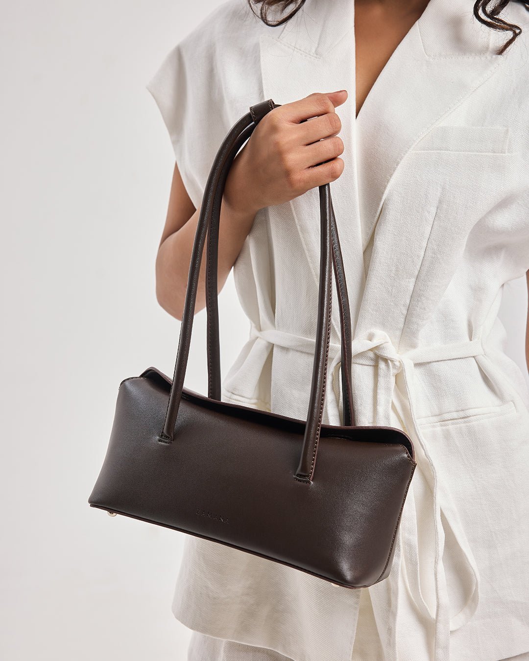 Dark brown tote bag close-up of two long top handles and top opening