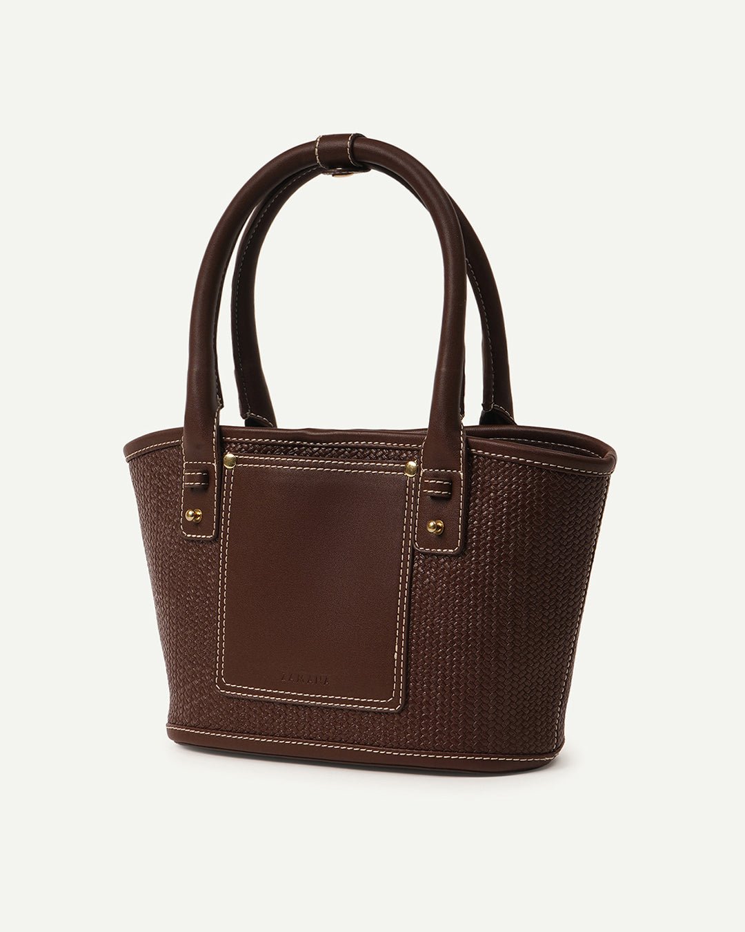 Brown woven tote bag side view with top handles, front pocket, and gold-tone hardware
