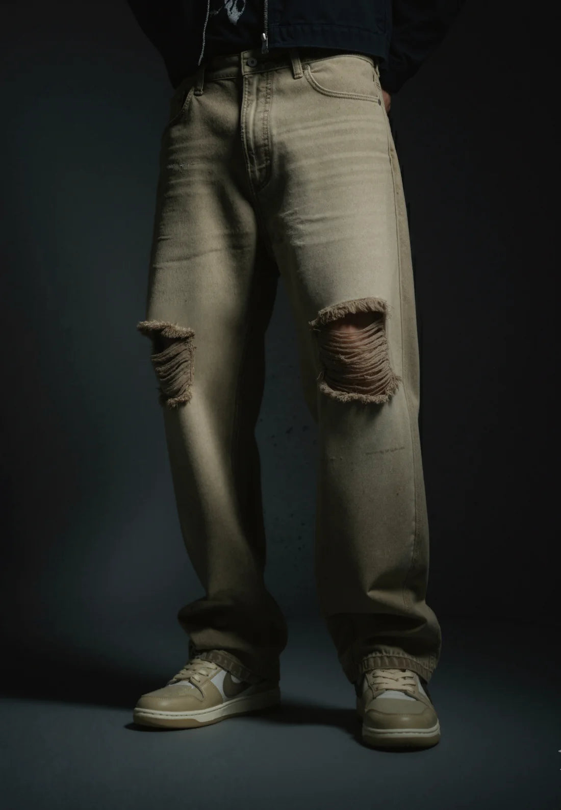 Sand-wash olive baggy denim jeans with torn knees, back patch pockets, relaxed fit.