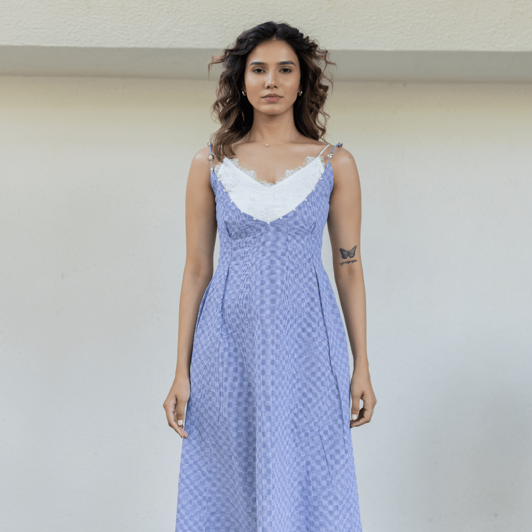 Blue midi slip dress with white scalloped V-neck and spaghetti straps, front view.