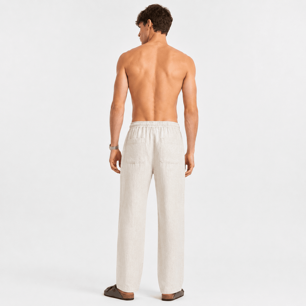 Back view of off-white linen pull-on pants with elastic waistband and relaxed straight legs.
