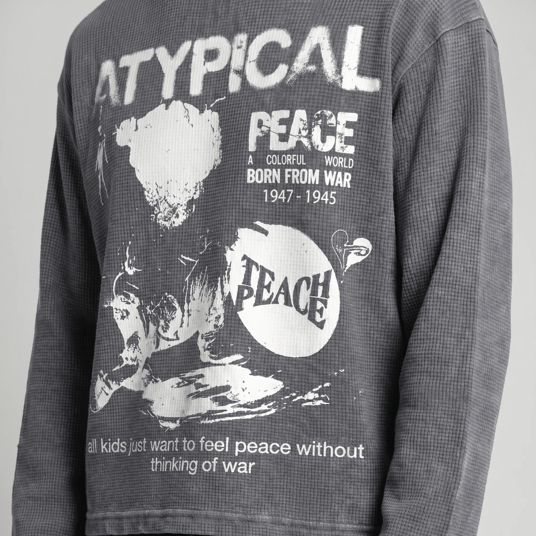 Dark gray waffle-knit sweatshirt chest close-up with large white peace and dove graphic