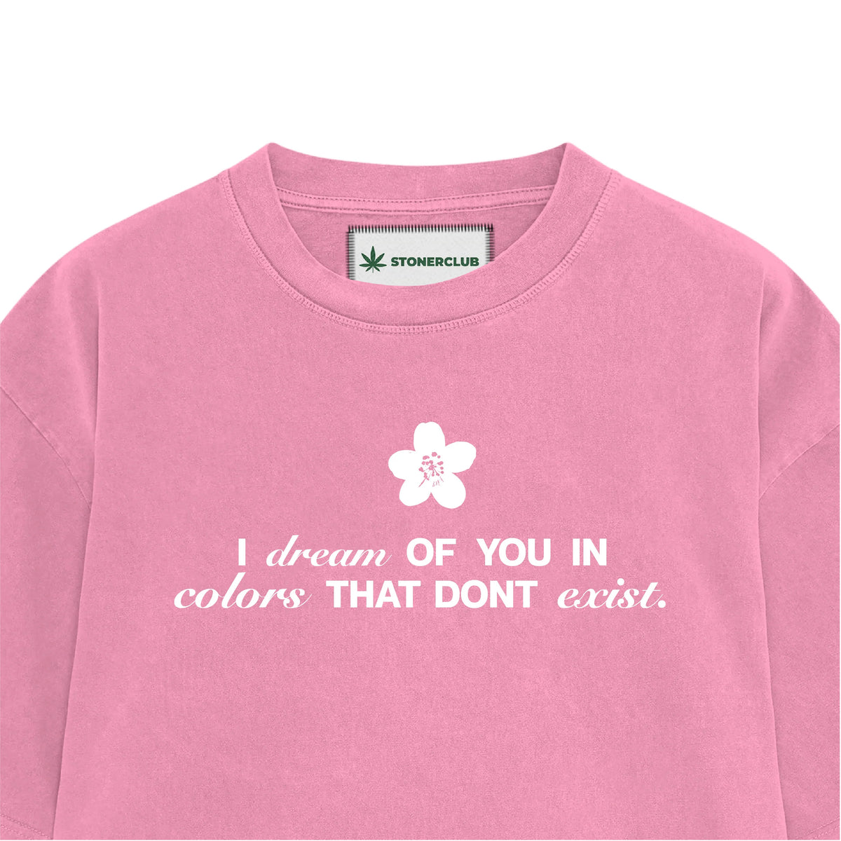 Pink boys' graphic T-shirt close-up with flower above 'I dream of you in colors...' text