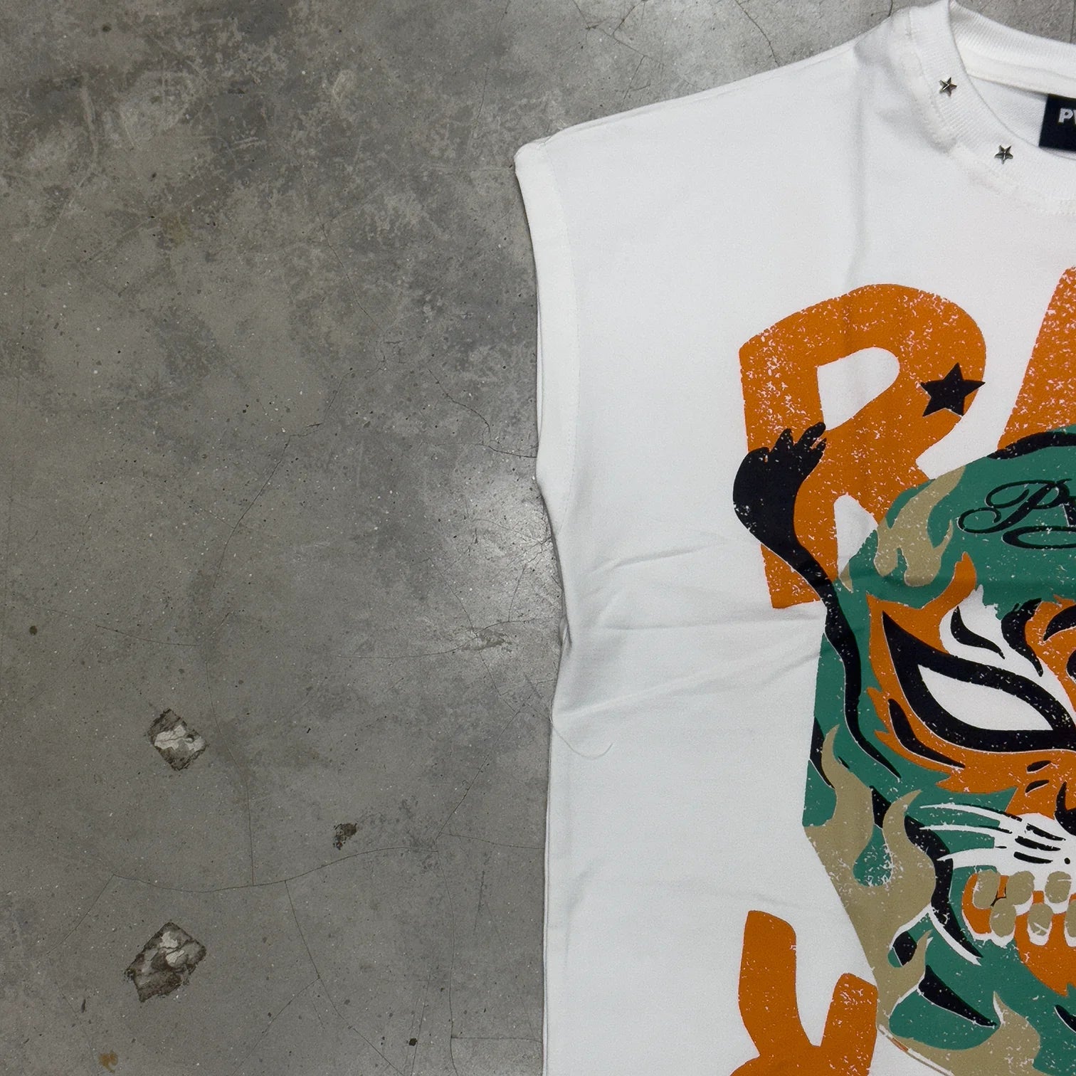 White sleeveless vest with partial orange monster graphic and crew neckline