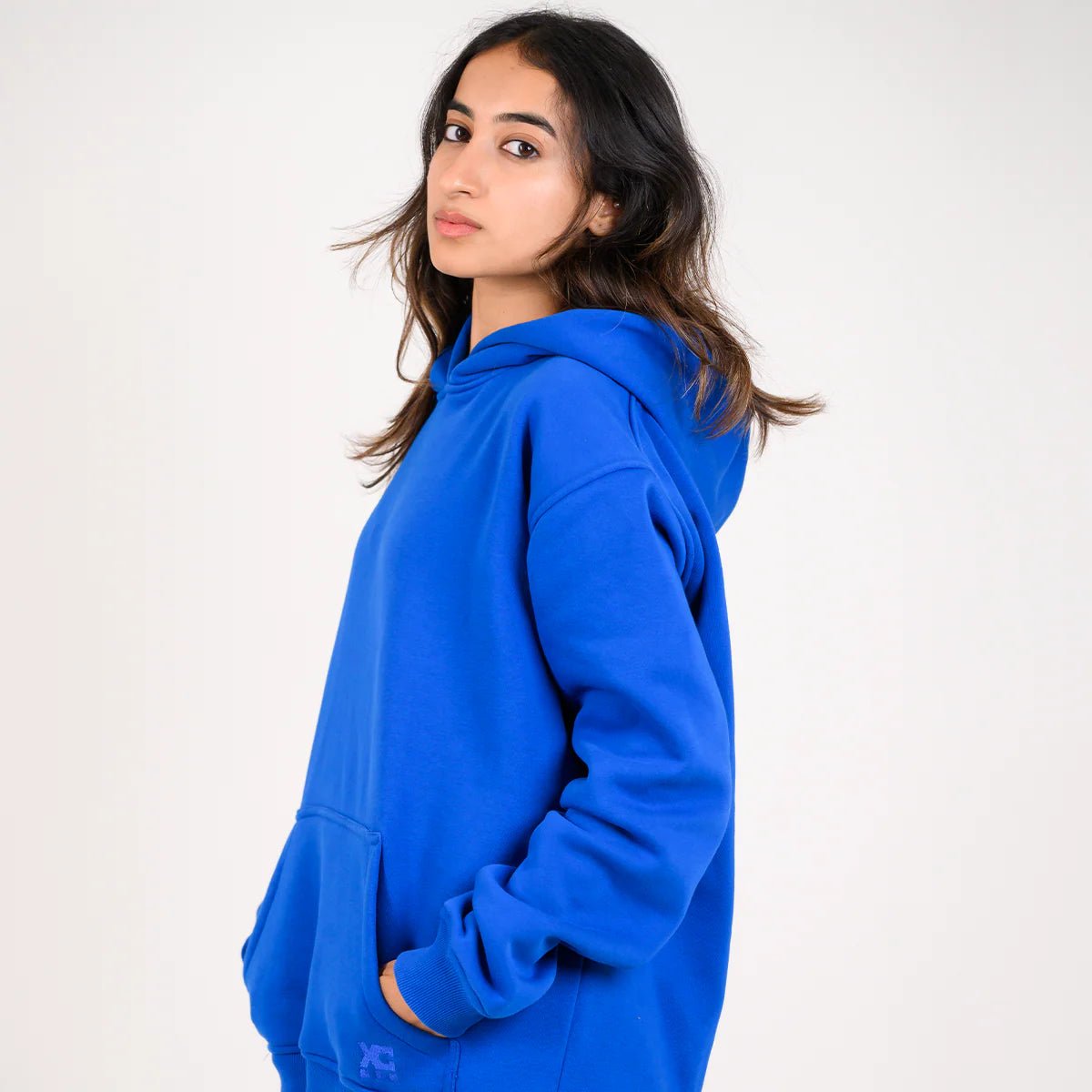 Blue pullover hoodie with hood and long sleeves, three-quarter side view
