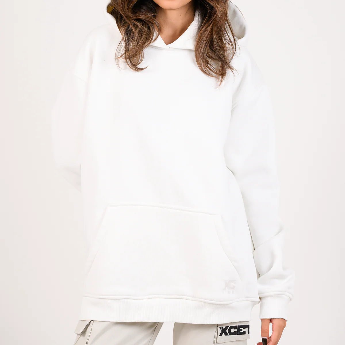 White pullover hoodie with hood and kangaroo pocket, hem with small XC logo.